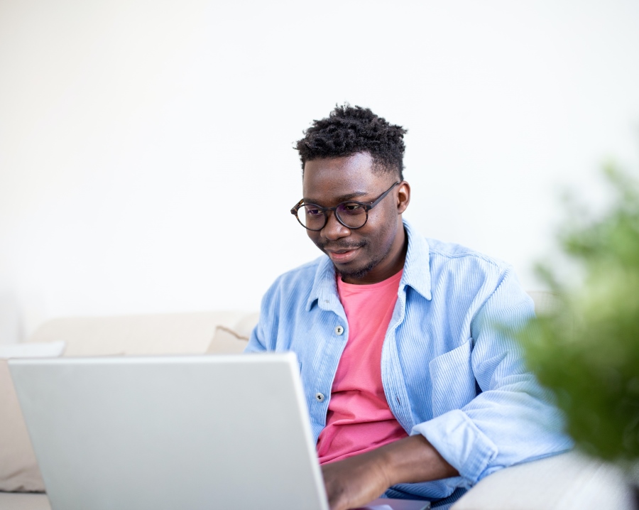 Man in Glasses Smiling at Telehealth Therapy