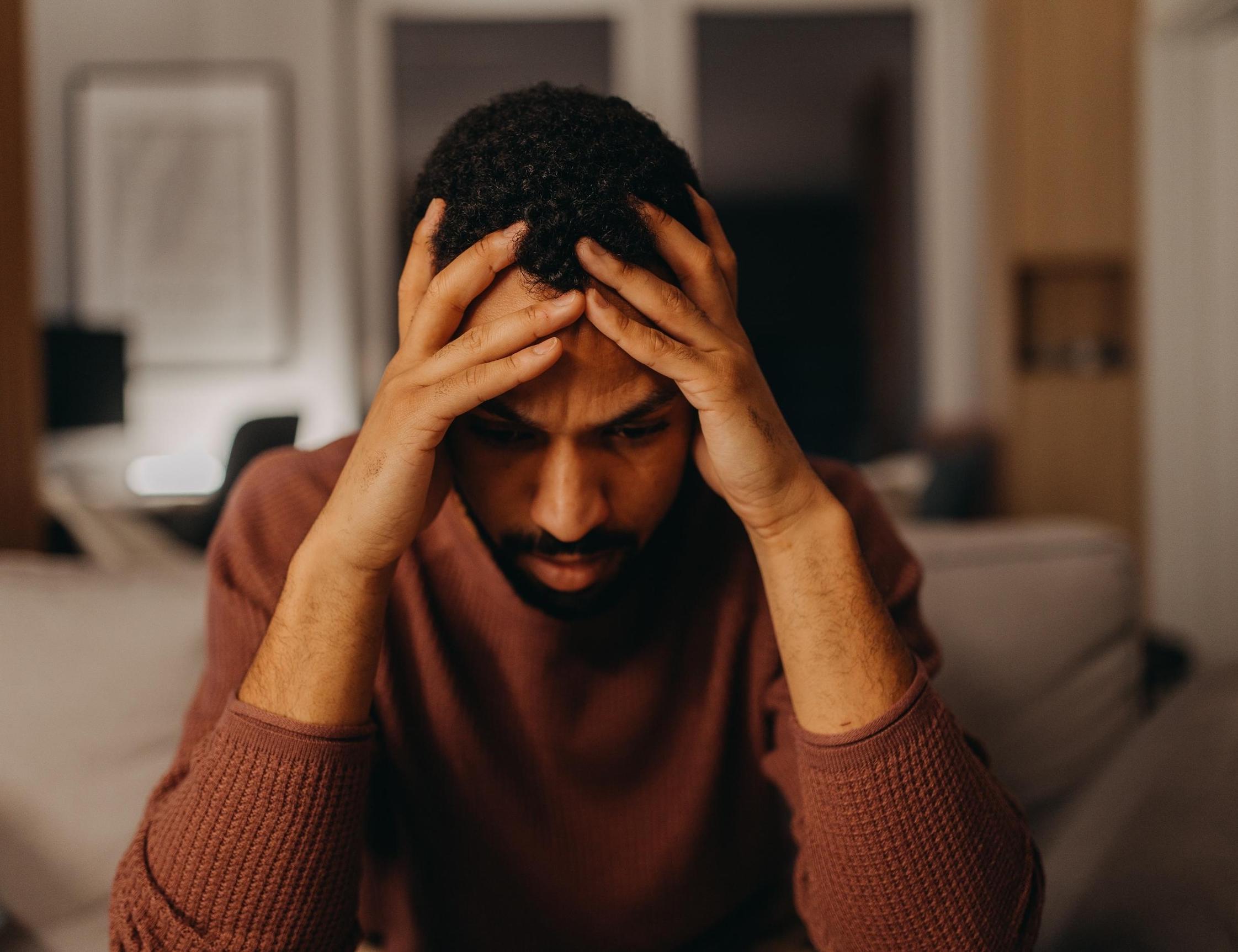 Stressed man with head in hands